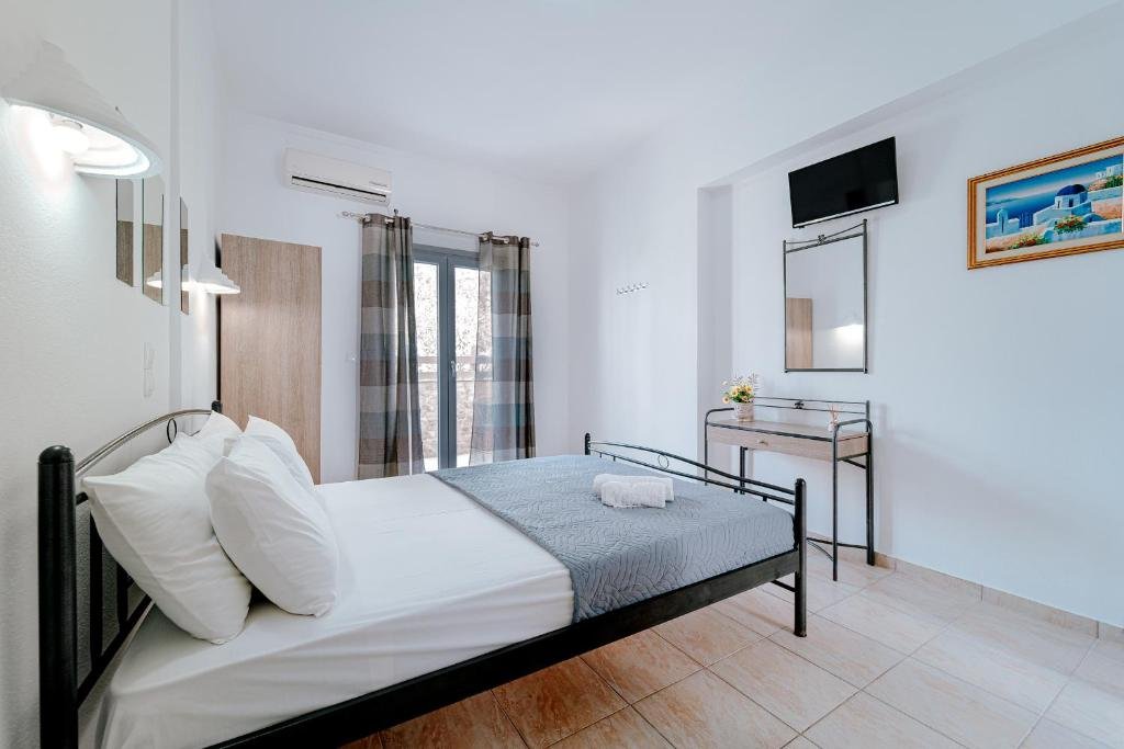 Habitación Doble de Marousi Rooms con cama doble, balcón y vista al jardín