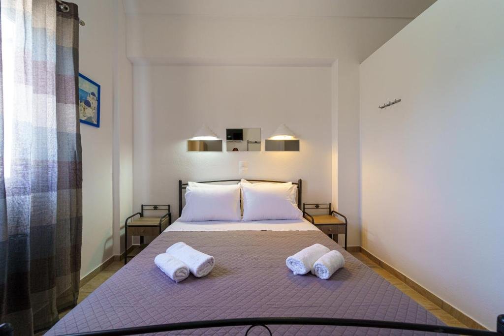 Habitación de Marousi Rooms con cama de hierro y balcón